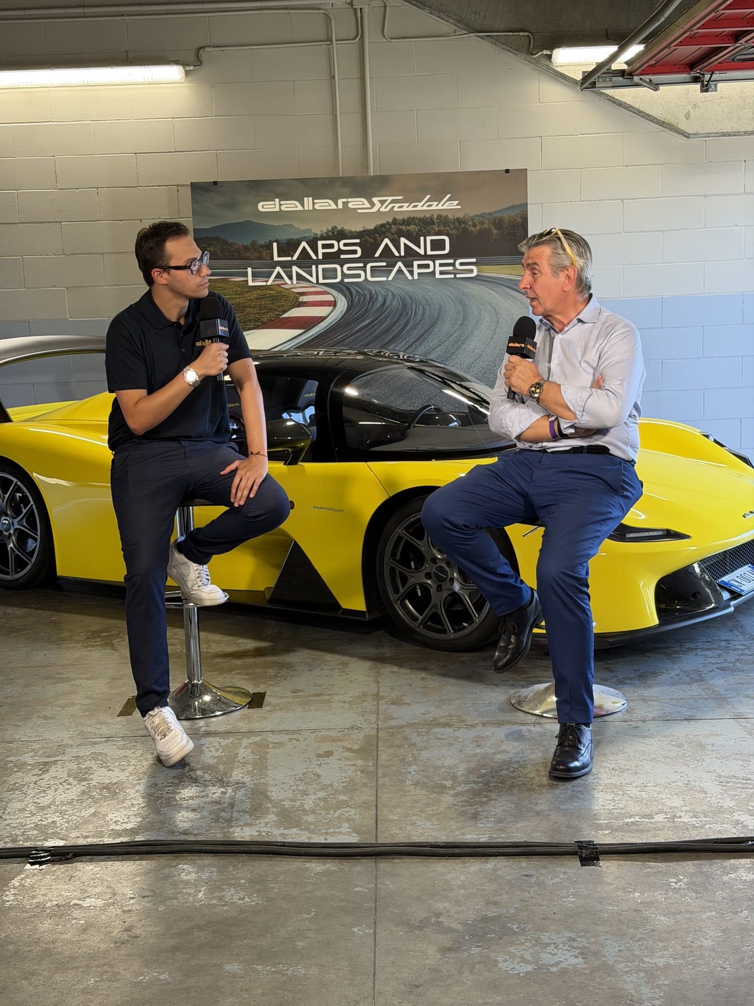 Lorenzo Mazzaschi intervista un ospite davanti alla Dallara Stradale